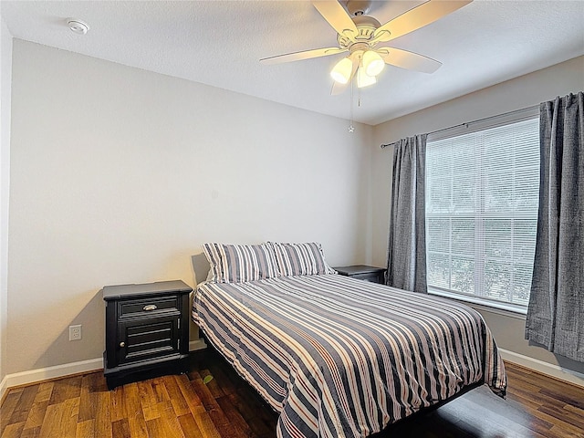 bedroom with wood finished floors, baseboards, and ceiling fan