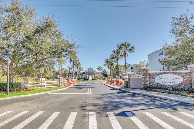 view of road featuring traffic signs, curbs, street lighting, and a residential view