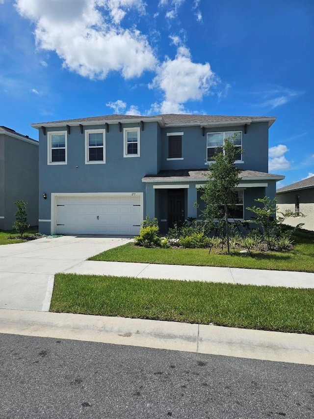 view of front facade featuring driveway, a garage, and stucco siding