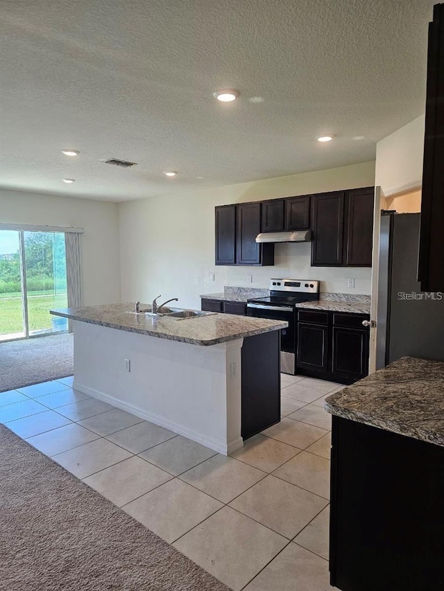 kitchen featuring visible vents, a sink, an island with sink, under cabinet range hood, and stainless steel appliances