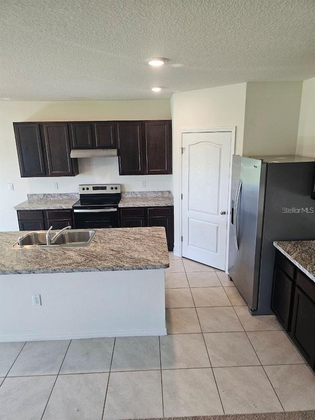 kitchen with a textured ceiling, light tile patterned flooring, under cabinet range hood, stainless steel appliances, and a sink