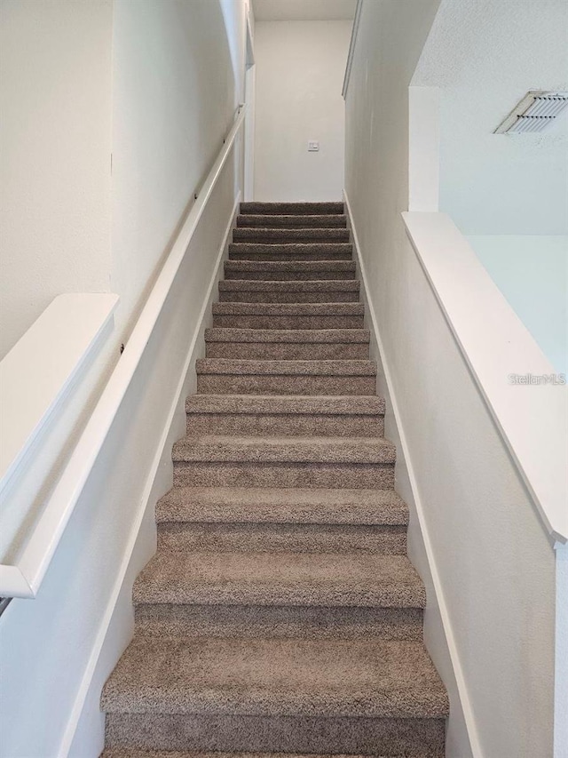 stairs featuring carpet floors