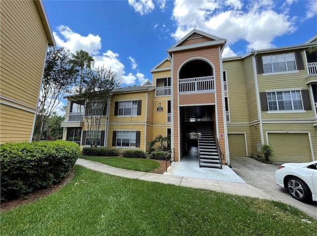 2314 Midtown Ter Unit 1113, Orlando, FL 32839 - view of building exterior featuring driveway, an attached garage, and stairway