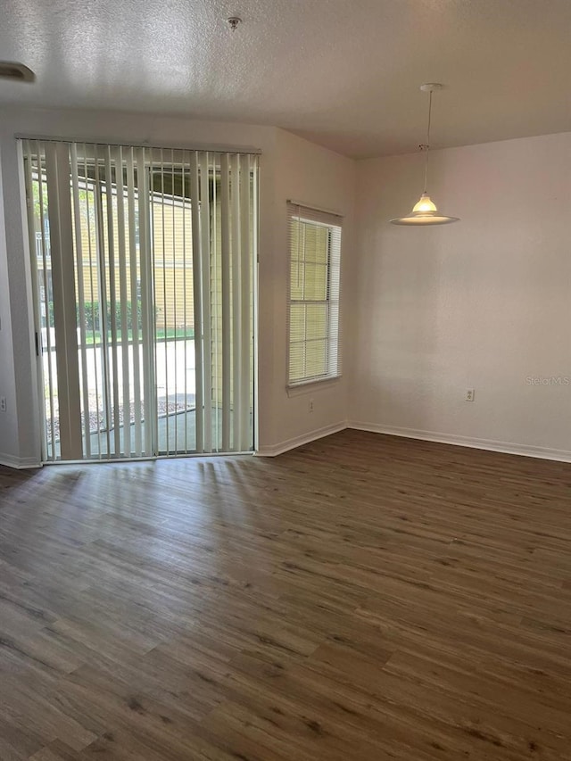 2314 Midtown Ter Unit 1113, Orlando, FL 32839 - empty room with dark wood-style flooring, plenty of natural light, and a textured ceiling