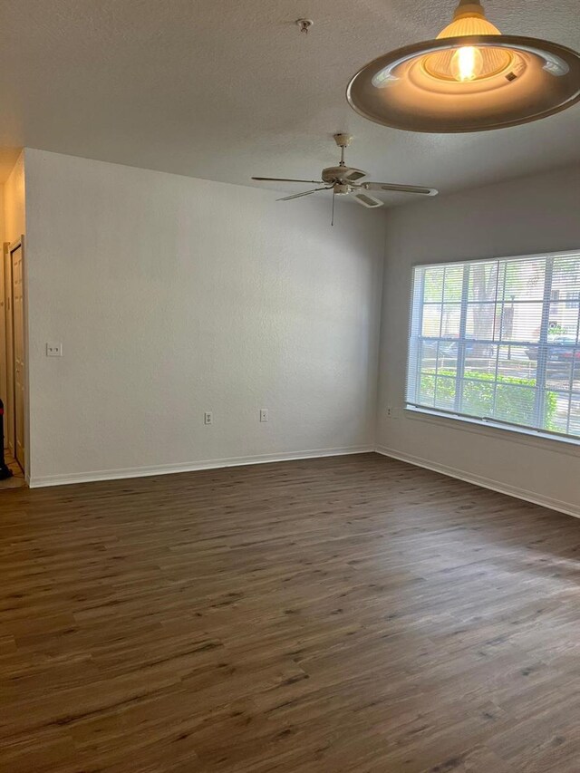 2314 Midtown Ter Unit 1113, Orlando, FL 32839 - empty room with a ceiling fan, a textured ceiling, baseboards, and dark wood finished floors