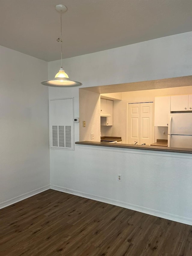 2314 Midtown Ter Unit 1113, Orlando, FL 32839 - kitchen featuring baseboards, white cabinetry, hanging light fixtures, dark wood-style floors, and freestanding refrigerator