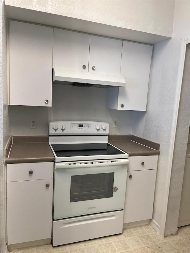 2314 Midtown Ter Unit 1113, Orlando, FL 32839 - kitchen with white cabinets, dark countertops, under cabinet range hood, electric stove, and a textured wall