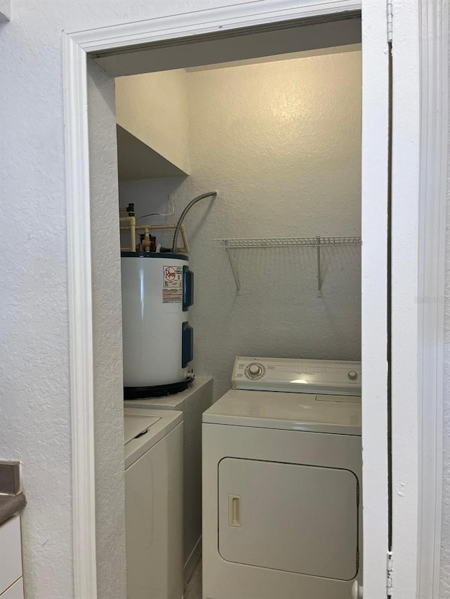 2314 Midtown Ter Unit 1113, Orlando, FL 32839 - laundry room featuring laundry area, a textured wall, electric water heater, and separate washer and dryer