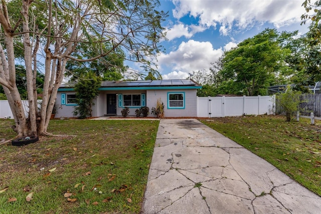 710 E Court, Longwood, FL 32750 - ranch-style house with a front yard, a gate, concrete driveway, fence, and roof mounted solar panels