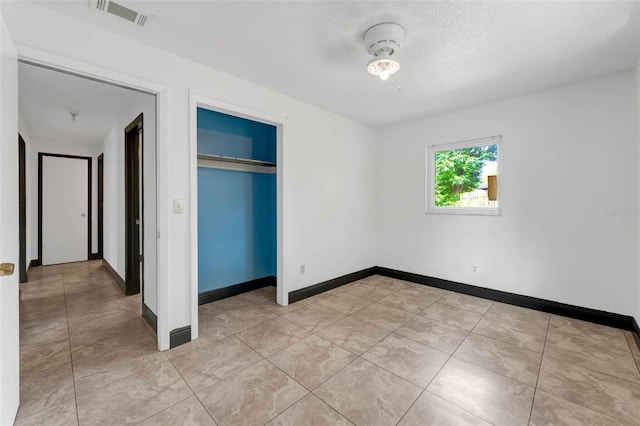 710 E Court, Longwood, FL 32750 - unfurnished bedroom with a closet, a textured ceiling, light tile patterned floors, baseboards, and visible vents