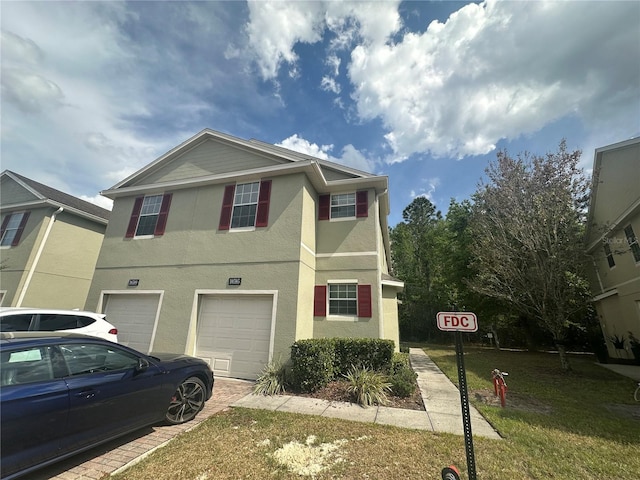 10595 Regent Square Dr Unit 1208, Orlando, FL 32825 - view of front of house featuring stucco siding, an attached garage, a front lawn, and driveway