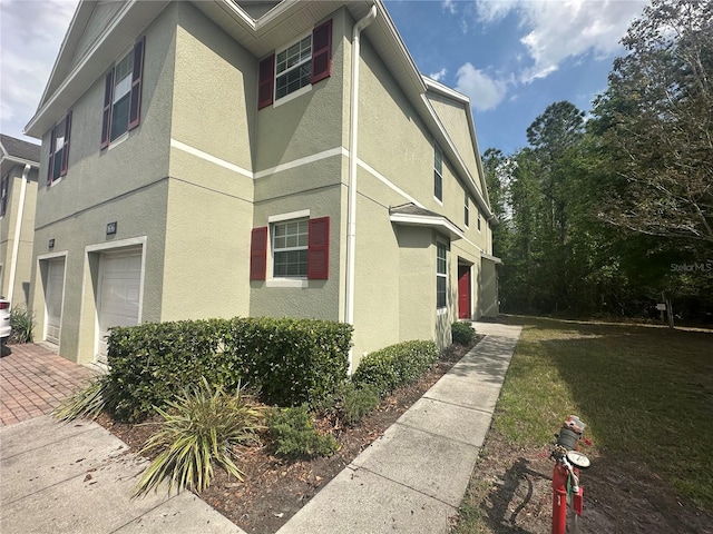 10595 Regent Square Dr Unit 1208, Orlando, FL 32825 - view of side of property featuring stucco siding and an attached garage