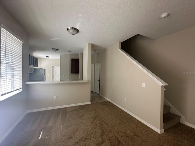 10595 Regent Square Dr Unit 1208, Orlando, FL 32825 - unfurnished living room featuring carpet flooring, baseboards, stairs, and a textured ceiling