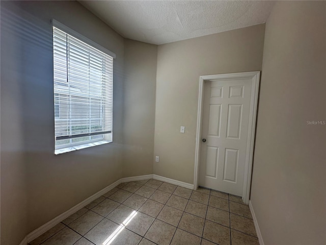 10595 Regent Square Dr Unit 1208, Orlando, FL 32825 - spare room with a textured ceiling, baseboards, and light tile patterned floors