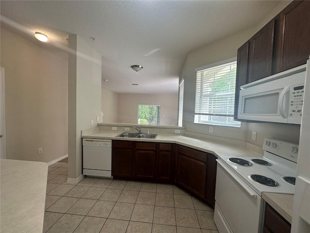 10595 Regent Square Dr Unit 1208, Orlando, FL 32825 - kitchen featuring light countertops, dark brown cabinetry, a sink, light tile patterned floors, and white appliances