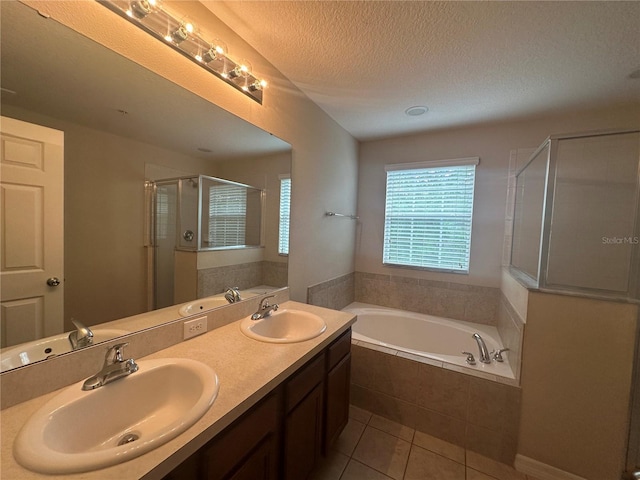 10595 Regent Square Dr Unit 1208, Orlando, FL 32825 - full bath featuring a stall shower, a textured ceiling, a sink, and a garden tub
