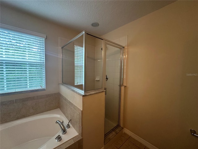 10595 Regent Square Dr Unit 1208, Orlando, FL 32825 - full bathroom featuring a garden tub, a textured ceiling, a stall shower, and tile patterned flooring