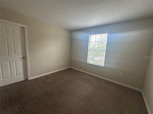 10595 Regent Square Dr Unit 1208, Orlando, FL 32825 - spare room with baseboards, a textured ceiling, and dark colored carpet