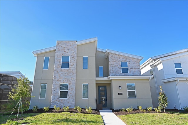 4221 Paragraph Dr, Kissimmee, FL 34746 - view of front facade with stone siding, stucco siding, and a front lawn