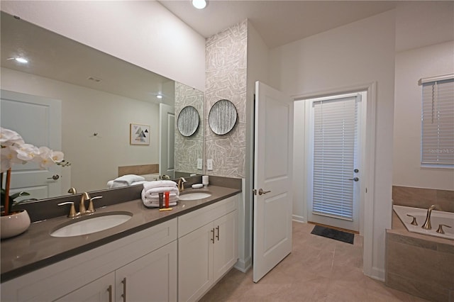 4221 Paragraph Dr, Kissimmee, FL 34746 - bathroom featuring double vanity, a relaxing tiled tub, a sink, and tile patterned floors