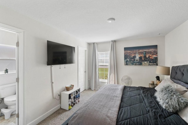 311 Athabasca Pl, Kissimmee, FL 34759 - bedroom with baseboards, ensuite bath, a textured ceiling, and light carpet