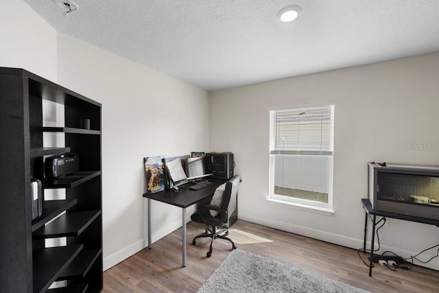311 Athabasca Pl, Kissimmee, FL 34759 - home office featuring a textured ceiling, baseboards, and wood finished floors