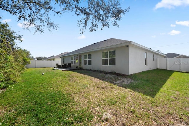 311 Athabasca Pl, Kissimmee, FL 34759 - back of property featuring a fenced backyard, stucco siding, and a lawn