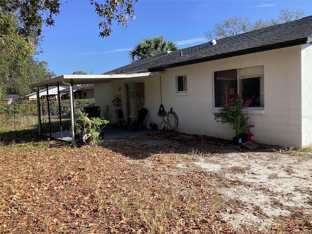 2948 Willow Bend Blvd, Orlando, FL 32808 - rear view of house with fence, concrete block siding, a patio, and roof with shingles