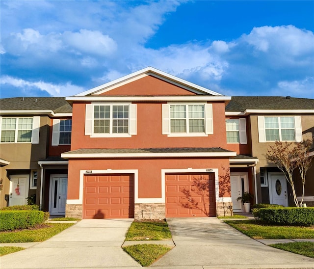 2934 Rodrick Cir, Orlando, FL 32824 - view of property featuring stucco siding, an attached garage, stone siding, and driveway