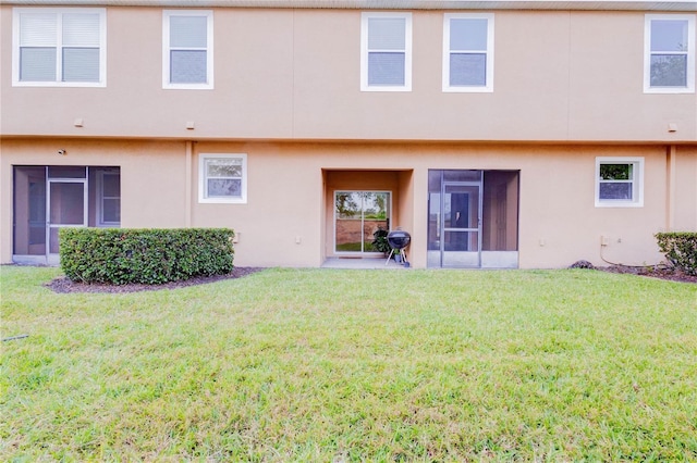 2934 Rodrick Cir, Orlando, FL 32824 - rear view of property with a lawn, a sunroom, and stucco siding