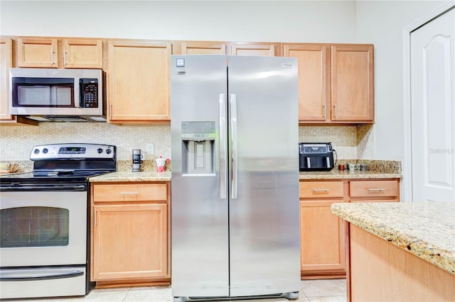 2934 Rodrick Cir, Orlando, FL 32824 - kitchen with light stone counters, tasteful backsplash, light brown cabinetry, appliances with stainless steel finishes, and light tile patterned floors