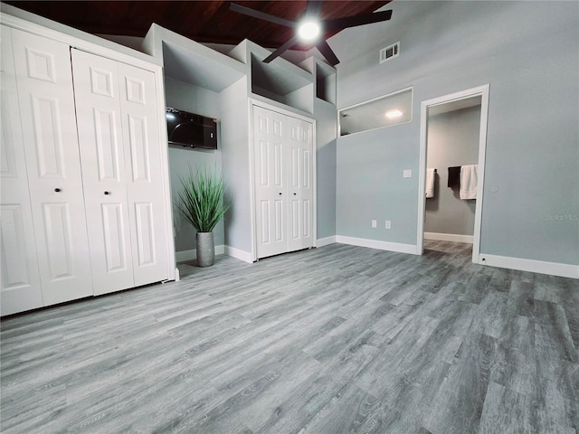 218 W Magnolia Ave, Longwood, FL 32750 - unfurnished bedroom with baseboards, visible vents, wood finished floors, two closets, and high vaulted ceiling