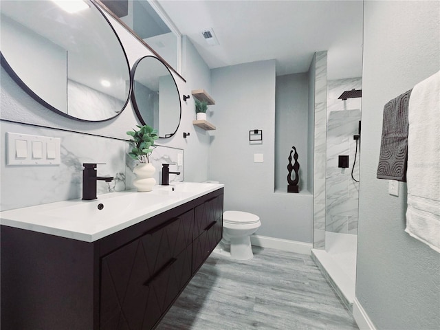 218 W Magnolia Ave, Longwood, FL 32750 - full bathroom featuring wood finished floors, toilet, a marble finish shower, a sink, and baseboards
