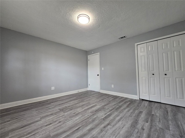218 W Magnolia Ave, Longwood, FL 32750 - unfurnished bedroom with a textured ceiling, a closet, baseboards, dark wood-style flooring, and visible vents
