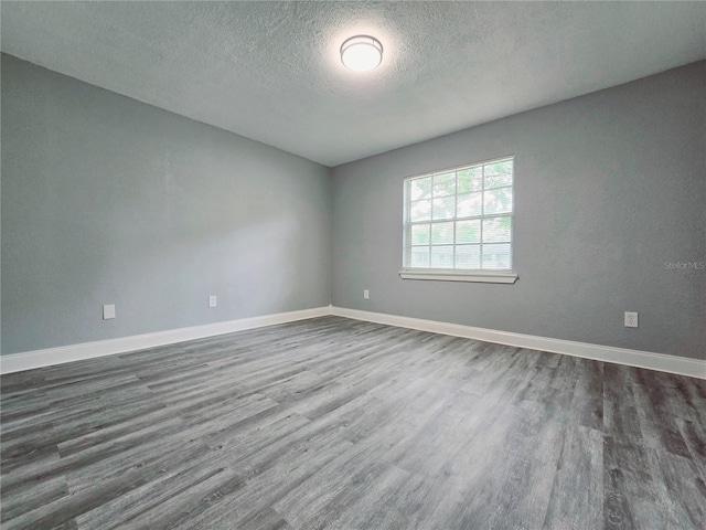 218 W Magnolia Ave, Longwood, FL 32750 - empty room featuring baseboards, a textured ceiling, and dark wood finished floors
