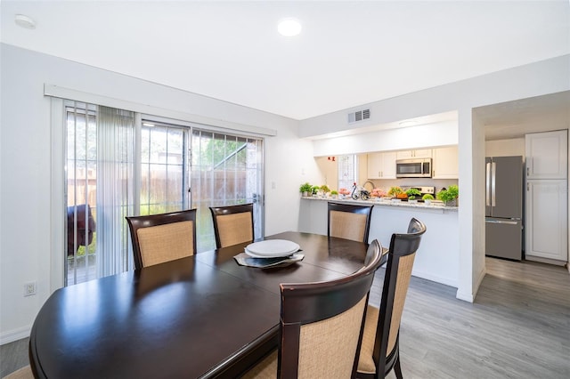 dining space with recessed lighting, visible vents, light wood-type flooring, and baseboards