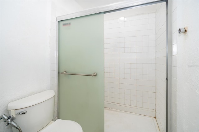 bathroom with a shower stall and toilet
