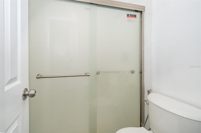 bathroom featuring an enclosed shower and toilet