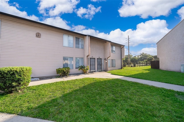 back of property with fence and a lawn