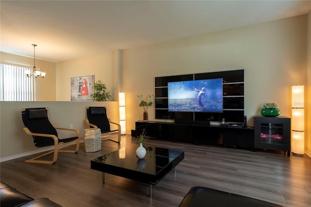 living area featuring a chandelier, wood finished floors, and baseboards