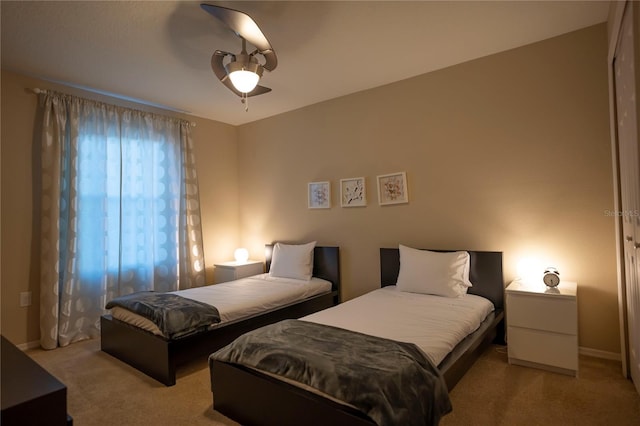 carpeted bedroom featuring ceiling fan and baseboards