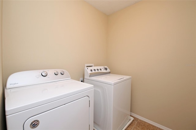 clothes washing area featuring independent washer and dryer, baseboards, and light tile patterned flooring