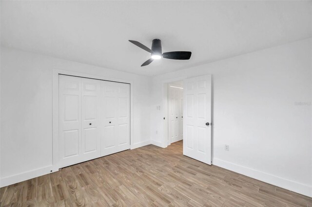 unfurnished bedroom with baseboards, a closet, and light wood-style floors