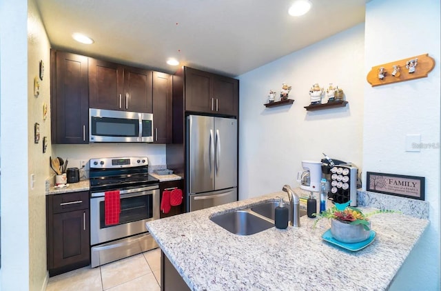 2610 Lodi Cir Unit 104, Kissimmee, FL 34746 - kitchen with appliances with stainless steel finishes, dark brown cabinets, light stone countertops, light tile patterned floors, and recessed lighting
