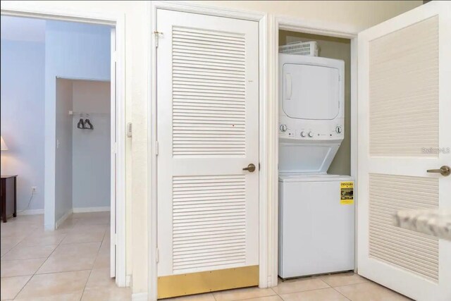 2610 Lodi Cir Unit 104, Kissimmee, FL 34746 - laundry area featuring stacked washer and clothes dryer and light tile patterned floors