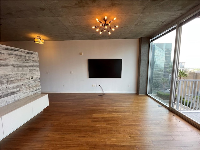 unfurnished living room featuring baseboards, floor to ceiling windows, and wood finished floors