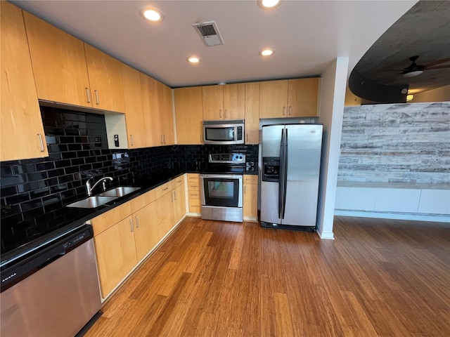 kitchen featuring visible vents, dark wood-style flooring, a sink, and stainless steel appliances