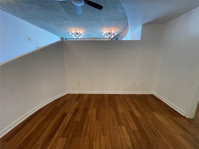 empty room featuring baseboards, wood finished floors, and a ceiling fan