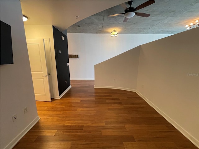 interior space with baseboards, ceiling fan, and wood finished floors