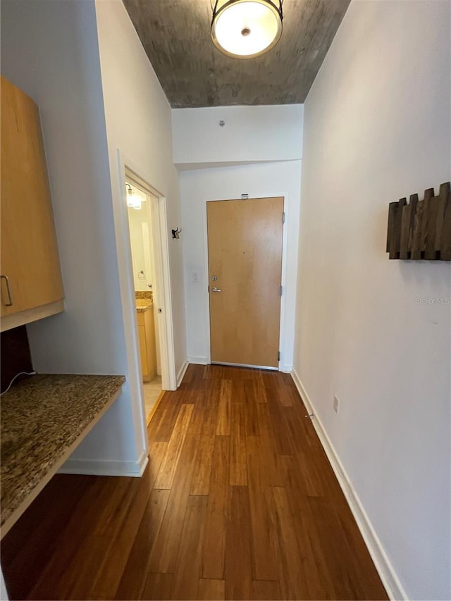 hallway with baseboards and wood finished floors